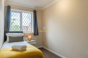 a bedroom with a yellow bed and a window at COSY 2 BED & FREE PARKING. NEAR HEATHROW/PINEWOOD in Slough