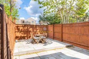 a patio with a table and a fence at COSY 2 BED & FREE PARKING. NEAR HEATHROW/PINEWOOD in Slough