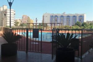 a fence with two potted plants in front of a pool at EDIFICIO ALGAIDA - NEW VISTA MONTAÑA - PLAYA DE LA CONCHA in Oropesa del Mar