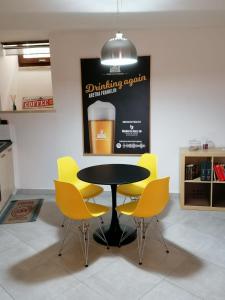 ein schwarzer Tisch und gelbe Stühle in einem Zimmer in der Unterkunft JAZZ Apartment Centro storico in Perugia