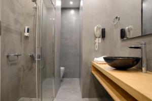 
a bathroom with a sink and a shower stall at Piraeus City Hotel in Piraeus
