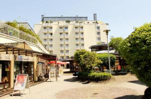 una calle con tiendas y un edificio alto en Hotel Gästehaus Forum am Westkreuz, en Múnich