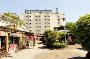 eine Straße mit Geschäften und einem hohen Gebäude in der Unterkunft Hotel Gästehaus Forum am Westkreuz in München