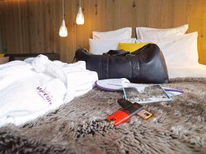 Ein Bett mit einer Handtasche und einer Waffe darauf. in der Unterkunft Mercure Valence in Valence