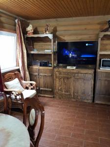 sala de estar con TV de pantalla plana y mesa en Загородный дом , сруб , рыбалка , баня , отдых , река , лес, en Troitskoye
