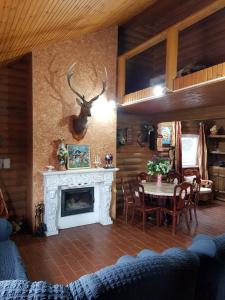 sala de estar con chimenea y mesa con sillas en Загородный дом , сруб , рыбалка , баня , отдых , река , лес, en Troitskoye