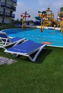 a pool with a blue reclining chair and a playground at Bel Mare Patio and Garden C110 in Międzyzdroje