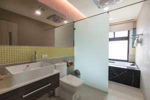 ein Badezimmer mit einem Waschbecken, einem WC und einem Spiegel in der Unterkunft 28.5 Bed and Breakfast in Xiyu