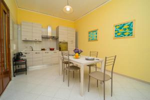 Ada's House في أتراني: مطبخ مع طاولة وكراسي وجدران صفراء