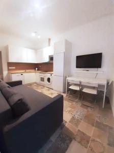 a living room with a couch and a table and a kitchen at Campo del Sur - Catedral in Cádiz