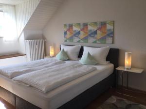 1 dormitorio con 1 cama blanca grande con 2 velas en Gästehaus Weber-Loskill, en Mehring