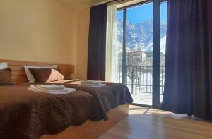 a bedroom with a bed with a view of a mountain at Hotel Horizon Kazbegi in Stepantsminda