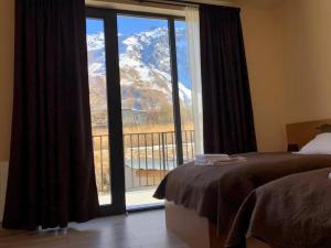 una camera da letto con finestra affacciata su una montagna di Hotel Horizon Kazbegi a Kazbegi
