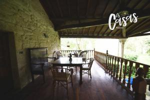 a patio with a table and chairs on a deck at As Casas Ribeira Sacra in Chantada
