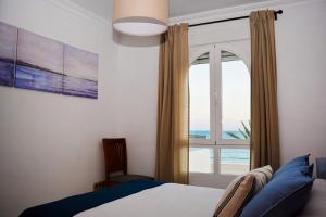 1 dormitorio con cama y ventana con vistas al océano en Apartamento Barrosaplaya1, en Chiclana de la Frontera