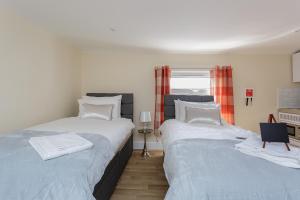 a bedroom with two beds and a window at St Mary's - Modern Central Huge Studio Apartments in Southampton