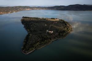 an island in the middle of a large body of water at Isola Polvese Resort in Castiglione del Lago