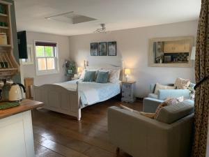 a bedroom with a bed and a couch at Thatched Cottage in Pulborough