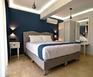 una camera da letto con un grande letto con pareti blu di Tahirağa Otel a Datça