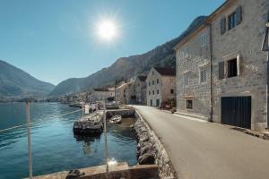 eine Straße neben einem Wasserkörper mit Gebäuden in der Unterkunft 18th Century Villa in the UNESCO Bay of Kotor in Kotor