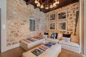 una sala de estar con 2 sofás y una pared de piedra. en 18th Century Villa in the UNESCO Bay of Kotor en Kotor