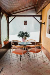 einen Tisch und Stühle in einem Zimmer mit Fenster in der Unterkunft Vila Verona Sobe in Palić