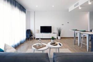sala de estar con sofá, mesas y TV en Rem Apartamentos en Torre-Pacheco