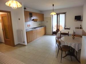 a kitchen and dining room with a table and chairs at Casa Endrizzi in Fai della Paganella