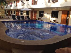 a large swimming pool with blue water in a building at Happy Valley Pattaya in Jomtien Beach