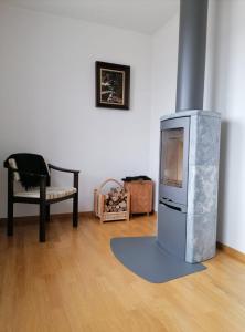 uma sala de estar com uma televisão e uma cadeira em Dimgården em Leksand