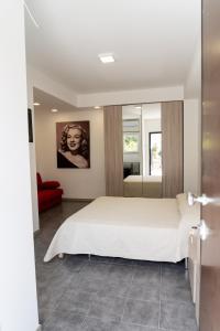 1 dormitorio con cama blanca y sofá rojo en Prestige house 4, en Scalea