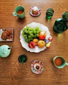 a table with a plate of fruit and cups of coffee at Le Stanze dell'Emiro in Sambuca di Sicilia