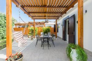 a patio with a table and chairs under a wooden pergola at Villa Cinzia-150 mt from the beach in Mondello