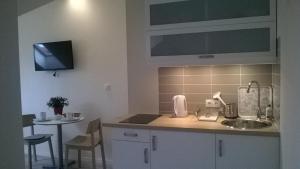 a kitchen with a sink and a counter top at Bursztynowy 2 in Karwia