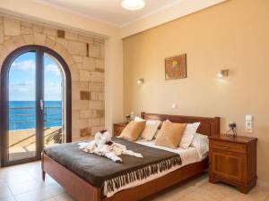 a bedroom with a bed and a large window at Xristinas Seaside Apartments in Kolymvari