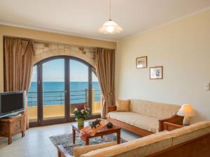 a living room with a couch and a television at Xristinas Seaside Apartments in Kolymvari