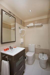 a bathroom with a toilet and a sink and a mirror at Wave Apartments in Villajoyosa