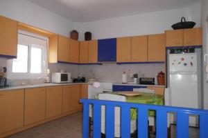 a kitchen with wooden cabinets and a white refrigerator at Παραλια Γαυρίου in Gavrion