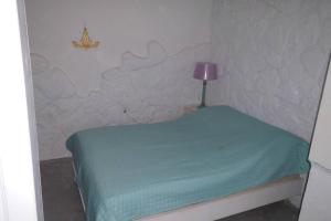 a small room with a bed with a lamp on it at Παραλια Γαυρίου in Gavrion