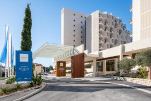 
a large building with a sign on the side of it at Valamar Meteor Hotel in Makarska
