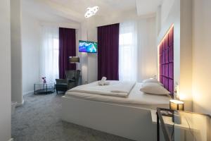 a bedroom with a large bed in a room with windows at Bed & Breakfast Donji Grad in Zagreb