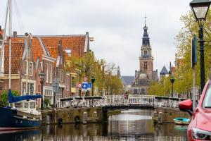 un puente sobre un río en una ciudad con una torre de reloj en Luttik Oudorp 30 en Alkmaar