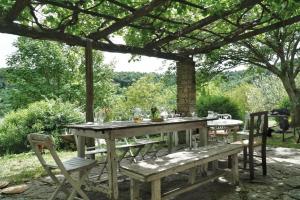 a wooden table and benches under a pergola at Il Casale di Aquarubra in Celleno