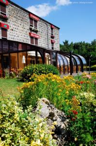 a building with a bunch of flowers in front of it at Les Hirondelles in Orcines