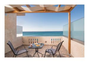 eine Terrasse mit einem Tisch und Stühlen am Strand in der Unterkunft Kastri Mare Sea View Residences by Estia in Keratókambos
