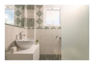 a bathroom with a sink and a mirror at Kastri Mare Sea View Residences by Estia in Keratokampos