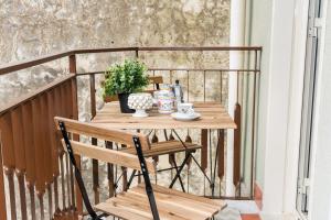 a wooden table on a balcony with a plant at Da Nonno Antonio in Santa Teresa di Riva