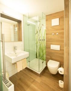 een badkamer met een wastafel en een glazen douche bij Stadthotel Giengen in Giengen an der Brenz