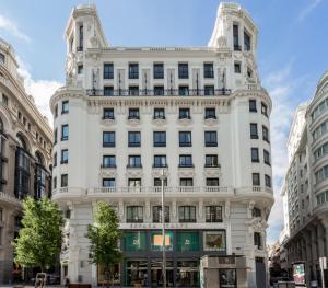 a large white building in the middle of buildings at Pestana CR7 Gran Vía Madrid in Madrid