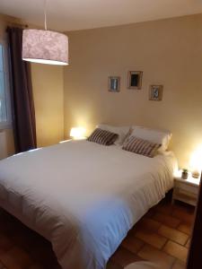 1 dormitorio con 1 cama blanca grande y 2 lámparas en L'Oustaou d'Aiglun en Aiglun